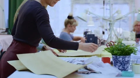 Dressmaker Marking Cut Lines on Textile Using a Paper Pattern and Chalk Vídeo Stock 336247411