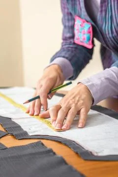 Dressmaker measuring tailor pattern on the table Stock Photos
