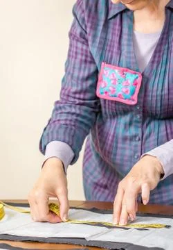 Dressmaker measuring tailor pattern on the table Stock Photos