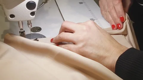 Dressmaker scribbles fabric on a sewing machine Stock Footage 140991218