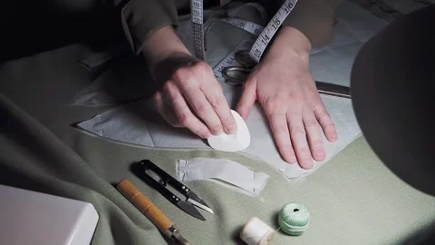 A dressmaker in a sewing workshop takes a pattern, at night, close-up Stock Footage 149207419