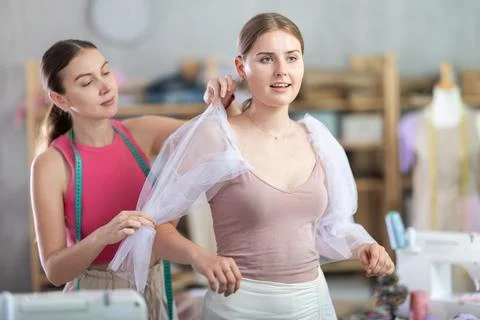 Dressmaker is trying on a sample of clothes with a client Stock Photos
