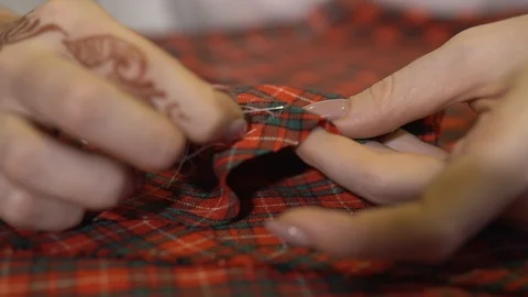 The dressmaker uses needle and thread to sew according to traditions of tailors. Stock Footage 88757526