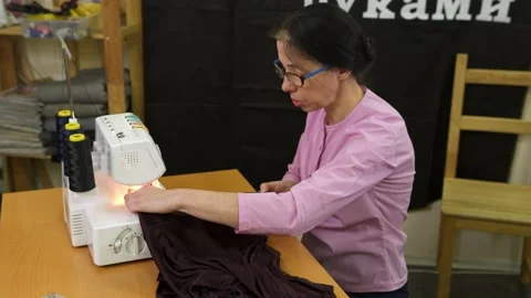 Dressmaker working on a sewing machine in her studio at table. Stock Footage 135805434