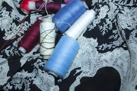 Dressmaking equipment, thread needle, placed on a thin white fabric Stock Photos