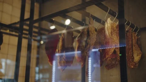 Dried and cured meat hangs in an electric dryer Stock Footage 302490033