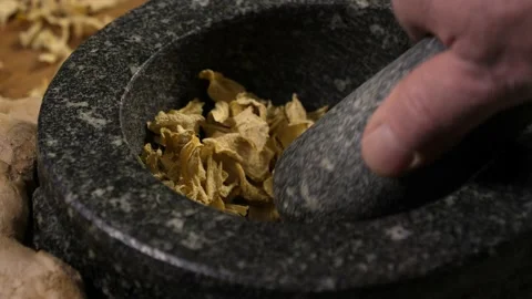 Dried and fresh ginger with a mortar and pestle on a wooden cutting board Video stock 204931070