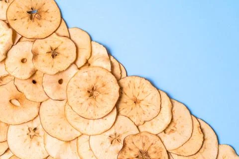 Dried apple chips pattern over blue background with copy space. 스톡 사진