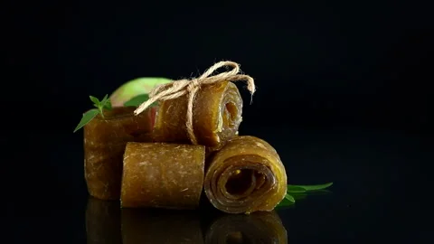 Dried apple fruit rolls with fresh apple and leaves on dark background Stock Footage 345336414