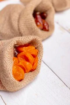 Dried apricots and fruit dates in canvas bags. Selective focus, blurred backg Stock Photos