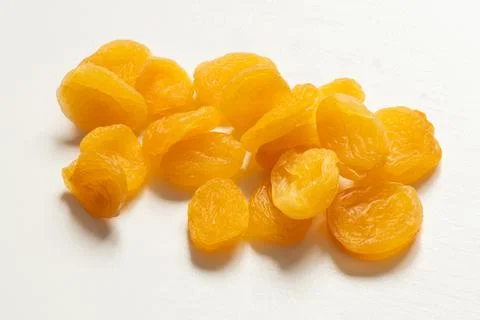 Dried apricots lying on a white surface, close-up, dried fruit Stock Photos