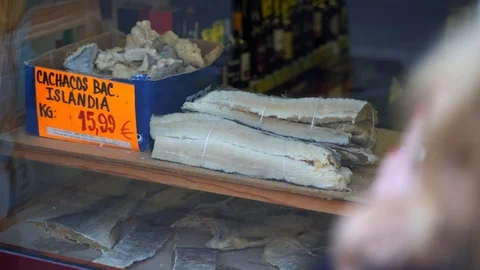 Dried bacalhau cod fish in a shop display, View behind customer, Portugal, Stock Footage 127574723