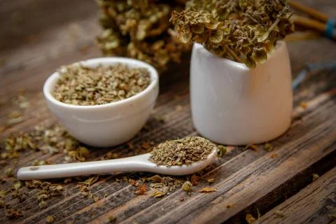 Dried basil spice in a small ceramic bowl Foto stock