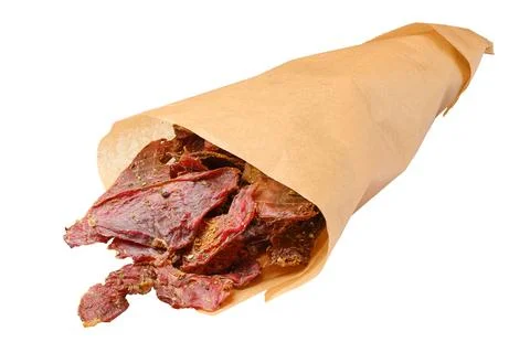 Dried beef jerky slices in parchment paper bag isolated on white Foto stock