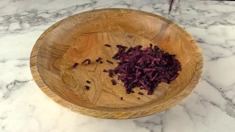 Dried beetroot slices falling in to wooden plate. slow motion. Stock Footage 243686342