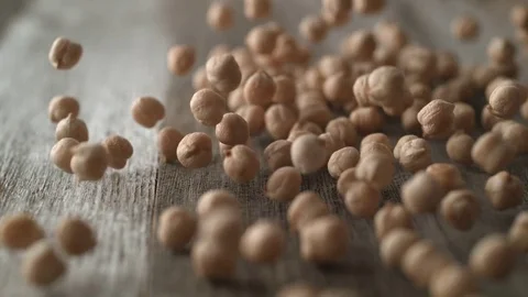 Dried chickpeas falling and rolling on a table. Slow Motion. Stock Footage 84925787