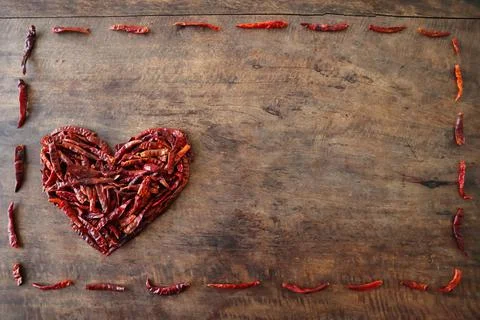 Dried chilli heart shape in a dotted chilli frame Stock Photos