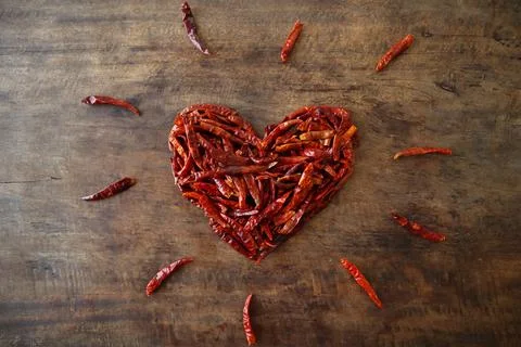 Dried chilli heart shape surrounded by chilli 'sparks' Stock Photos