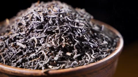 Dried Chinese Tea Leaves Dropping To An Wooden Bowl - extreme close up - slow Video stock 150294101
