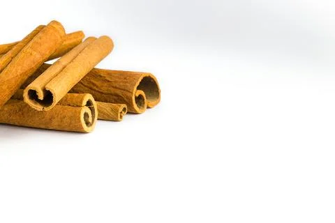 Dried cinnamon bark pieces arranged on a white background, showcasing their.. Stock Photos