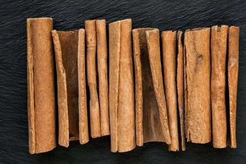 Dried Cinnamon Sticks Placed Vertically on Black Stone Surface Background Stock Photos
