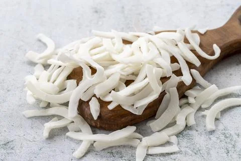 Dried coconut slice on gray background. Dried fruit in sunlight. close up Stock Photos