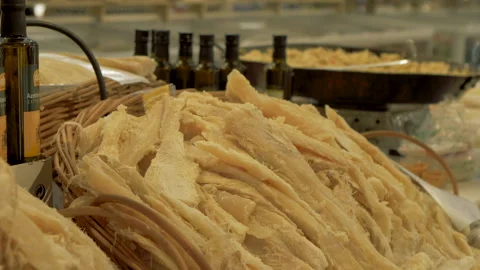 Dried cod in a supermarket stall, with someone cooking in background. Stock Footage 130556857