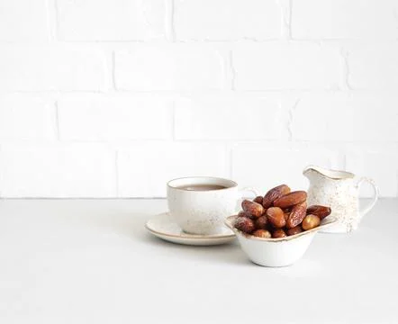 Dried dates and a cup of tea on white background. Copy space. Stock Photos