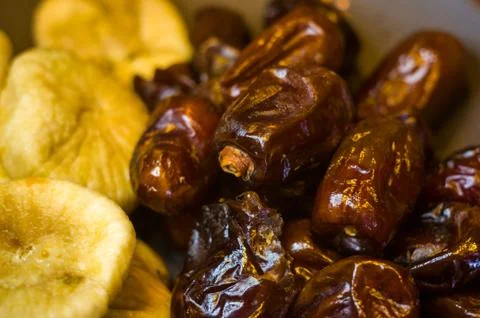 Dried dates and figs in a ceramic plate on a wooden table Foto stock