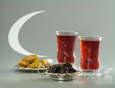 Dried dates and figs, tea in armudu glasses and crescent Stock Photos
