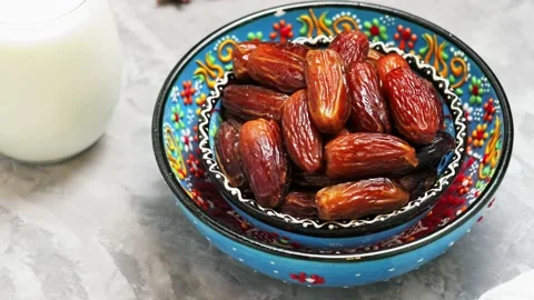 Dried dates and milk on a gray background. Bowl of pitted dates on concrete Stock Footage 238562558