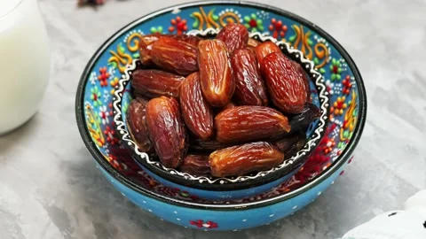 Dried dates and milk on a gray background. Bowl of pitted dates on concrete Stock Footage 238562598