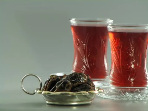 Dried dates and red karkade tea in armudu glasses Stock Photos