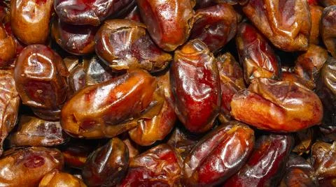 Dried dates background top view.Background of ripe dried dates. Stock Photos