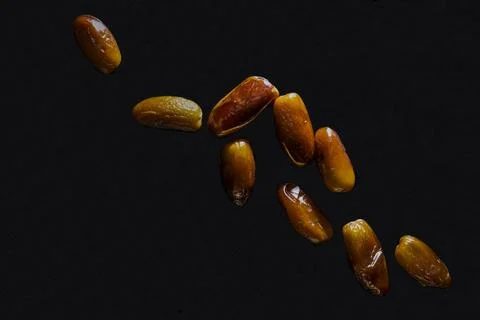 Dried dates on a black background in hard light. Stock Photos