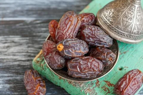 Dried dates on a bronze plate. Stock Photos