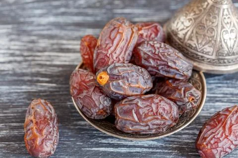 Dried dates on a bronze plate. Stock Photos