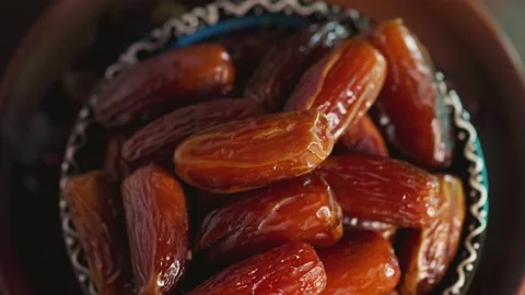 Dried dates close up. Sweet pitted dates in bowl. Ramadan Kareem Stock Footage 237400703