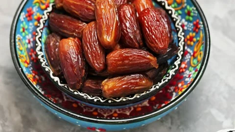 Dried dates on concrete. Bowl of pitted dates on a gray background. Ramadan Stock Footage 237401171