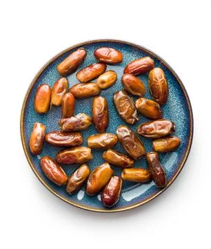 Dried dates fruit on plate isolated on white background. Stock Photos