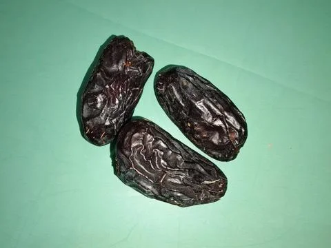 Dried Dates on Green Surface for Culinary Use Stock Photos