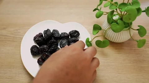 Dried Dates on Heart-Shaped Plate with Plant Stock Footage 320726067