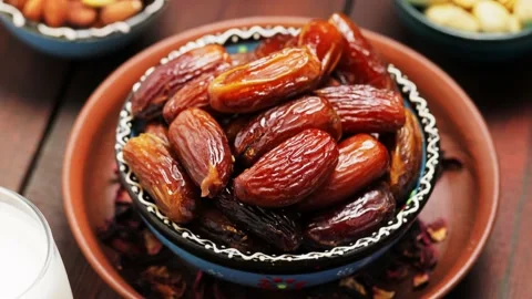 Dried dates, nuts and milk on a wooden background. Pitted dates in a bowl Stock Footage 237825011