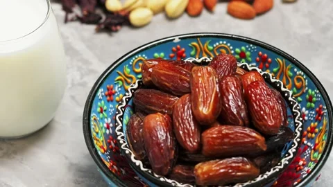 Dried dates, nuts and milk on concrete. Bowl of pitted dates Stock Footage 237827855