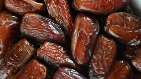 Dried Dates Spinning on Dark Surface. Top-Down Seamless Motion Loop Stock Footage 325529397