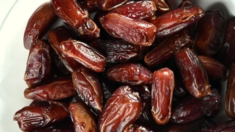 Dried Dates Spinning on Dark Surface. Top-Down Seamless Loop, Natural Sweet Stock Footage 325984301