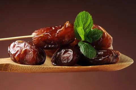Dried dates on spoon Stock Photos