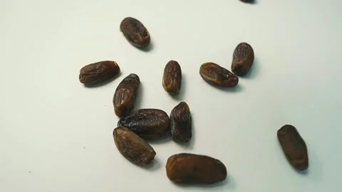 Dried Dates on White Surface, A group of dried dates scattered on a white s.. Stock Footage 304974966