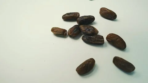 Dried Dates on White Surface, A group of dried dates scattered on a white s.. 動画素材 304974990