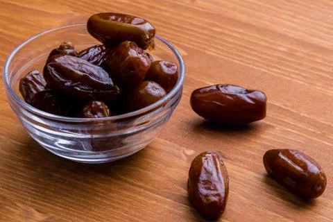 Dried dates on wooden table Stock Photos